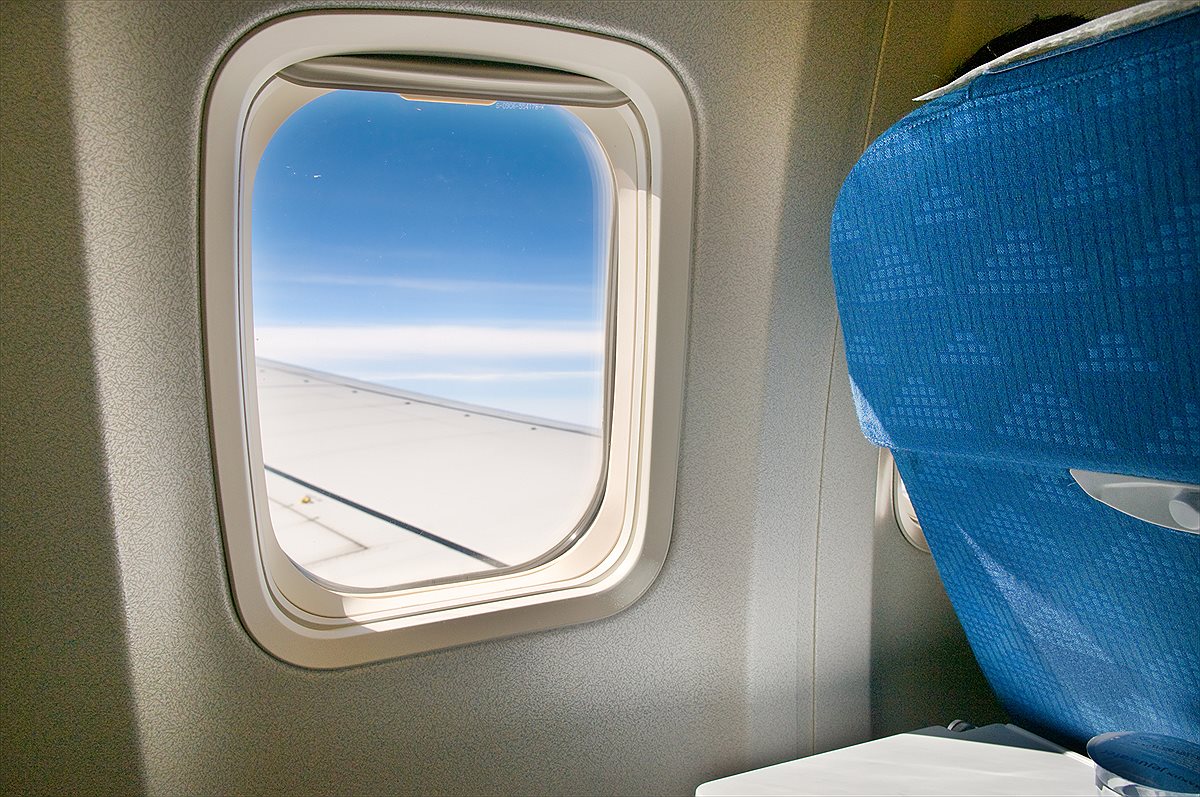 View from an airplane window above the clouds